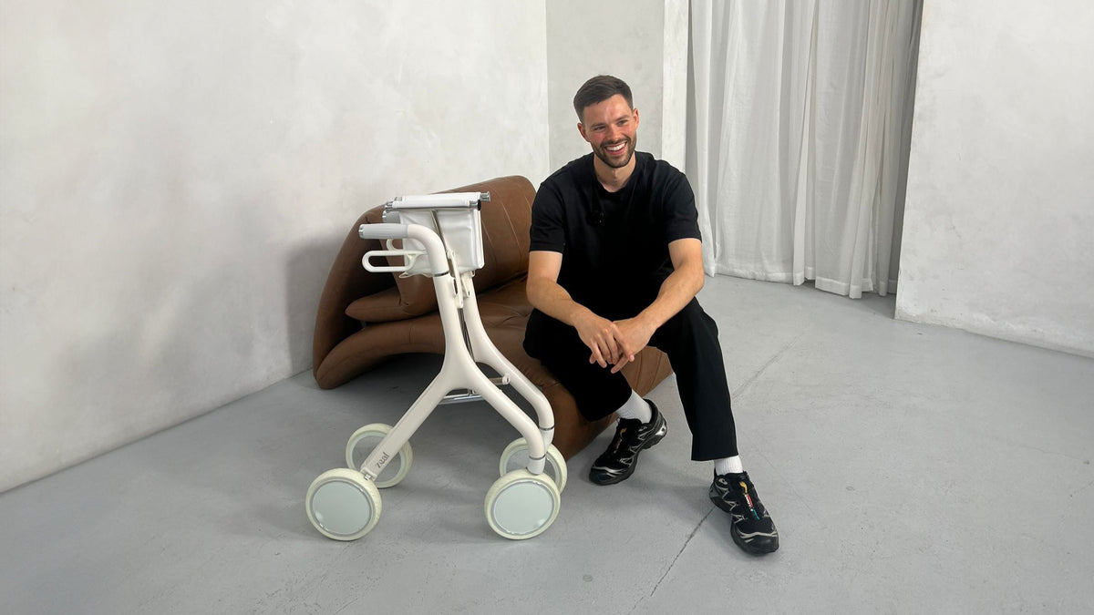 Nick, chartered physiotherapist, sitting beside a Zeal walker
